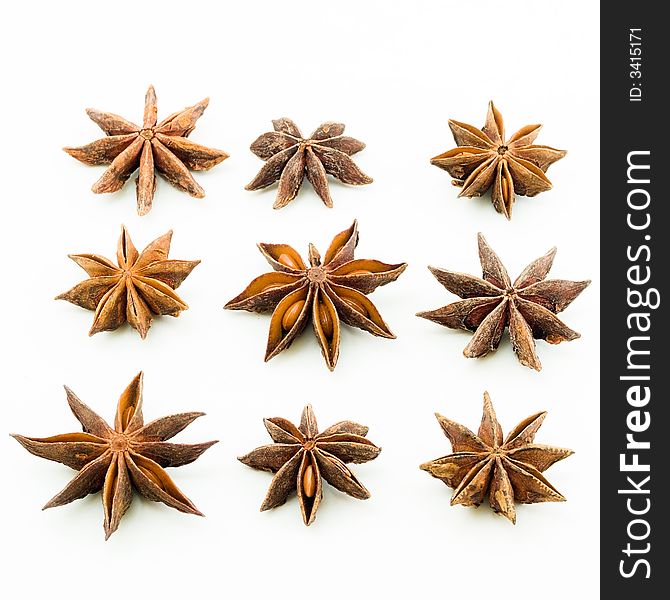 Arrangement of nine star anise in three rows with each star showing the bottom view. Arrangement of nine star anise in three rows with each star showing the bottom view