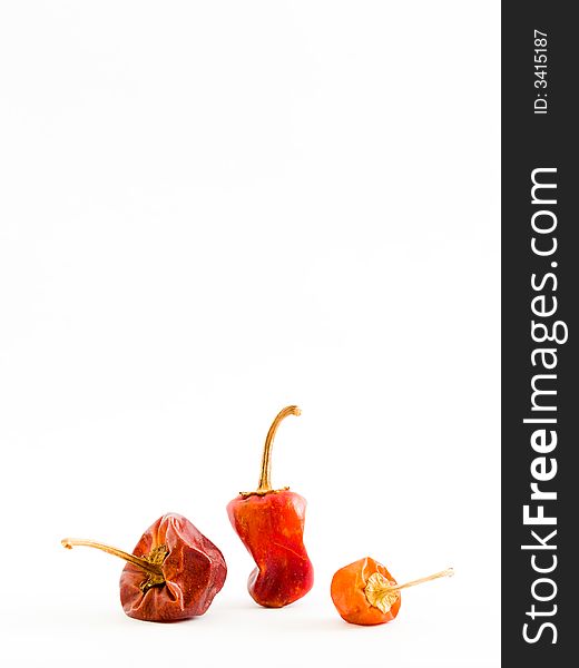 Still life of three dried Habanero chilies of different shapes, sizes and colour. Still life of three dried Habanero chilies of different shapes, sizes and colour.