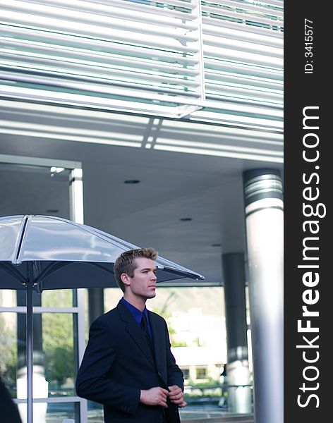 One business man buttoning suit standing in front of building exterior. One business man buttoning suit standing in front of building exterior