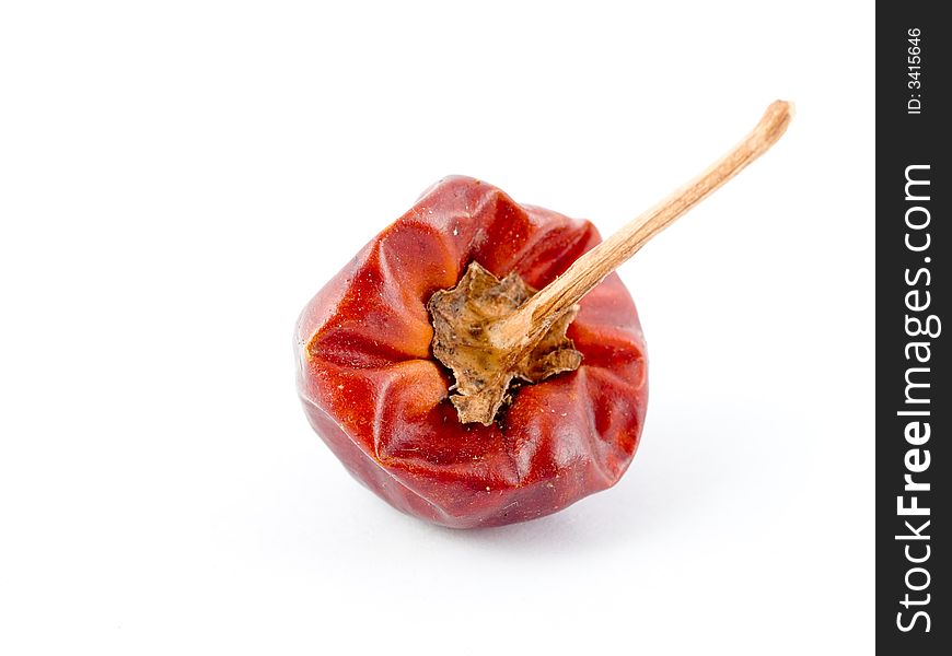 Still life of a small round dried wrinkled very hot chili with stalk, seen from its top,  isolated on white background. Still life of a small round dried wrinkled very hot chili with stalk, seen from its top,  isolated on white background.