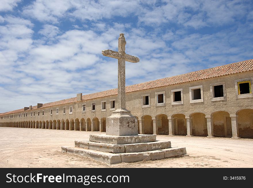 Cross with old monastery in background, Portugal