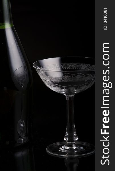 Champagne Botlte with a glass on a black background. Champagne Botlte with a glass on a black background