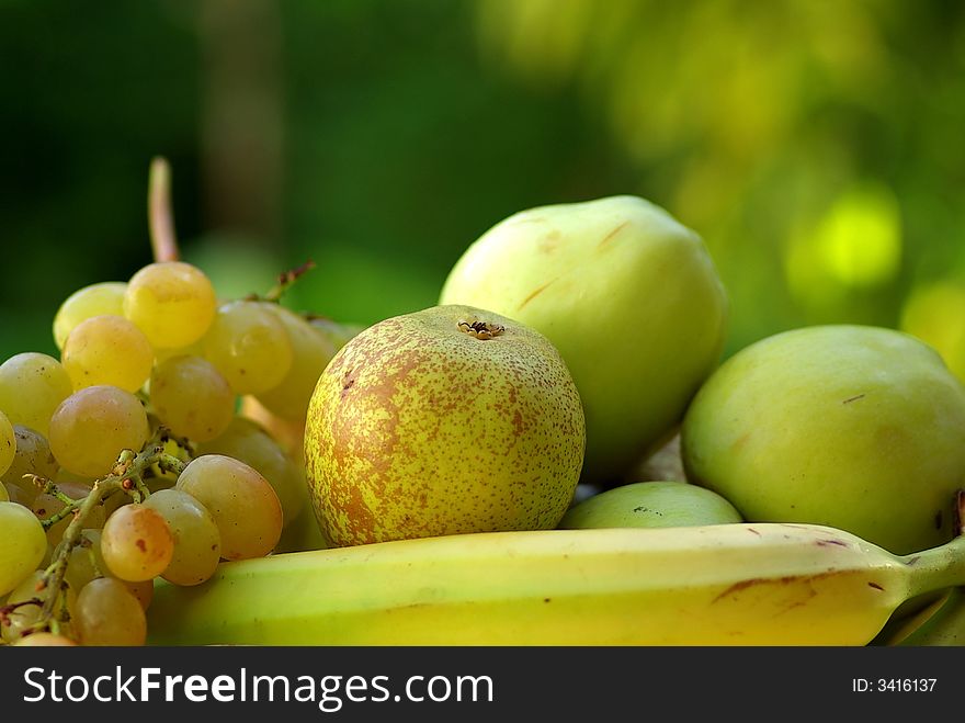 Yellow banana and green apple on green background. Yellow banana and green apple on green background