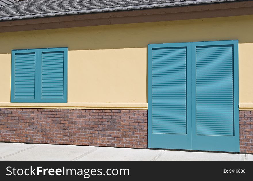 Bright green shutters on a pink stucco and brick building. Bright green shutters on a pink stucco and brick building