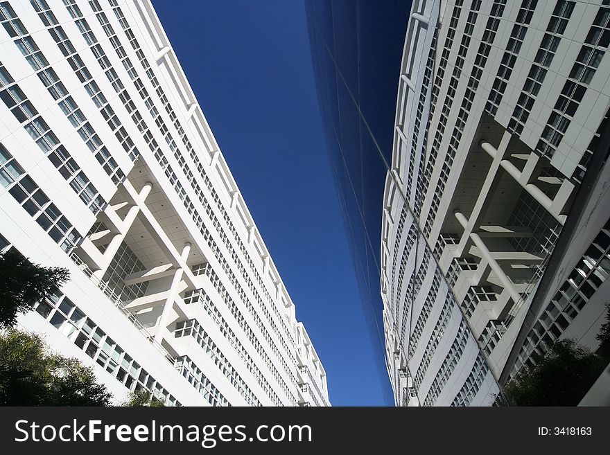 Upward view of City Hall and reflection in the glass exterior of a theater. The Hague, Holland.