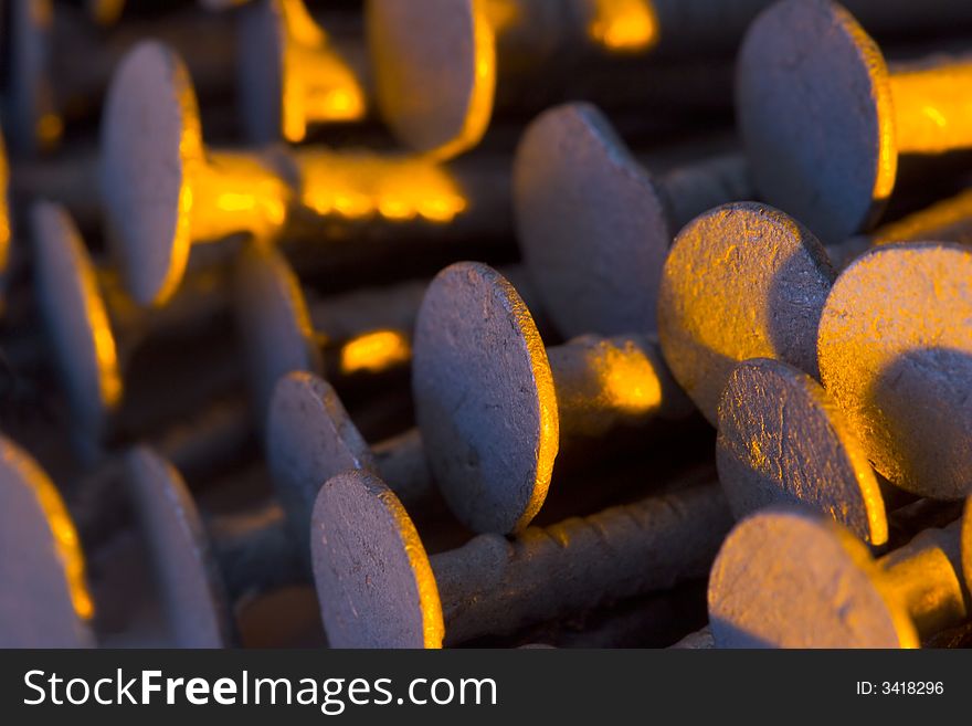 A stack of old nails under colored lights.