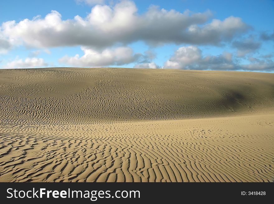 Dune like a dessert. Sky and clouds. Far North New Zealand