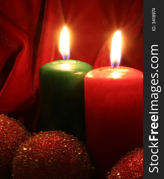 Two Candles, red and green and Christmas tree decorations