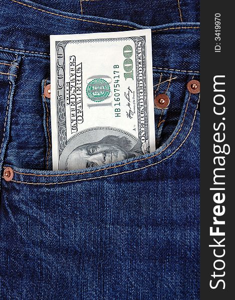 A one hundred dollar bill in the pocket of denim trousers.  Photographed in a studio. A one hundred dollar bill in the pocket of denim trousers.  Photographed in a studio.