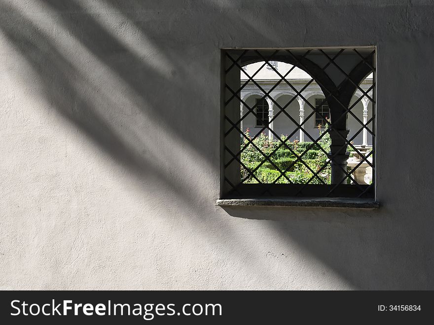 View of old italian cloister from a small grated window. View of old italian cloister from a small grated window