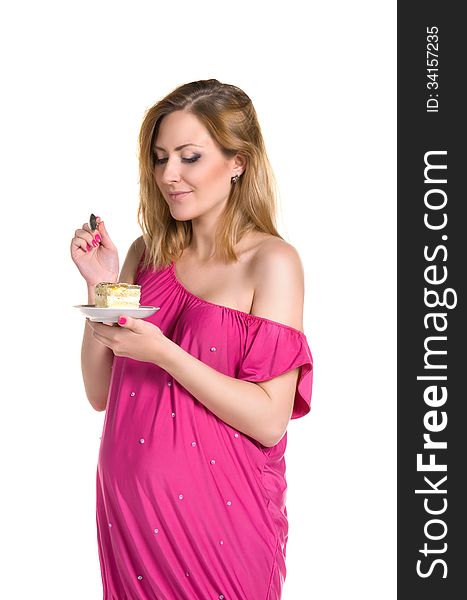 Pregnant woman in pink dress eating cake. Pregnant woman in pink dress eating cake
