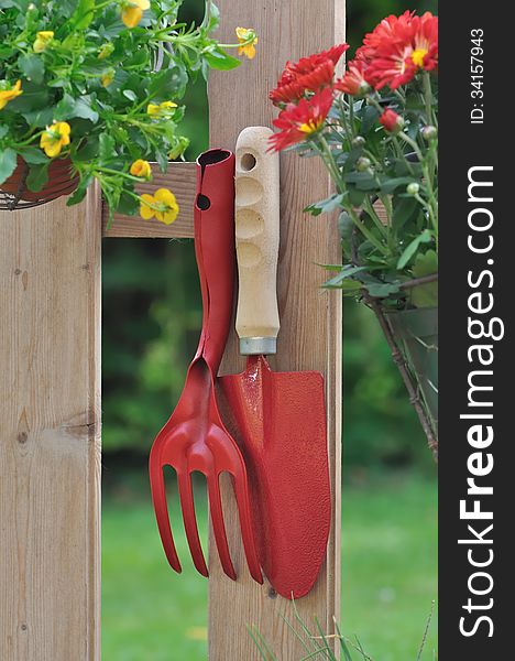 Gardening tools and flower pot hanging on a fence. Gardening tools and flower pot hanging on a fence