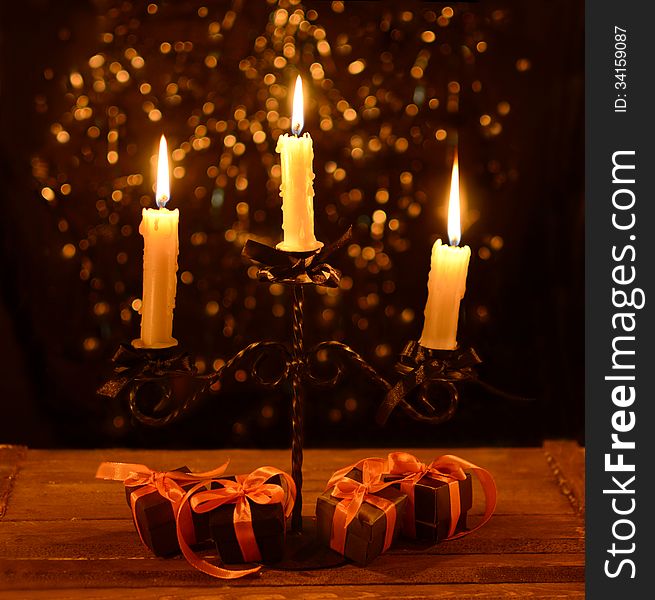 Candelabra with four Halloween gifts in black wrapping on the black shining background. Candelabra with four Halloween gifts in black wrapping on the black shining background