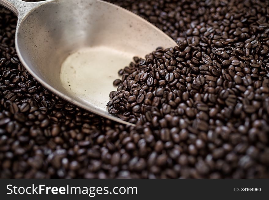 Coffee beans in bag with stainless scoop utensil