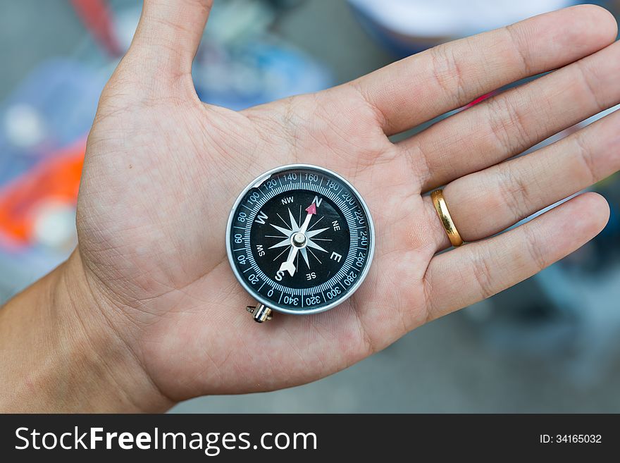 Metal compass on bare hand