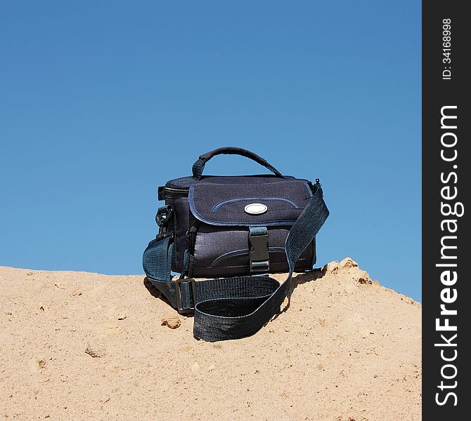 Bag for the camera on top of a sandy hill. Bag for the camera on top of a sandy hill