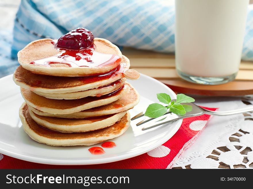 Pancakes on a white plate with strawberry jam. Pancakes on a white plate with strawberry jam