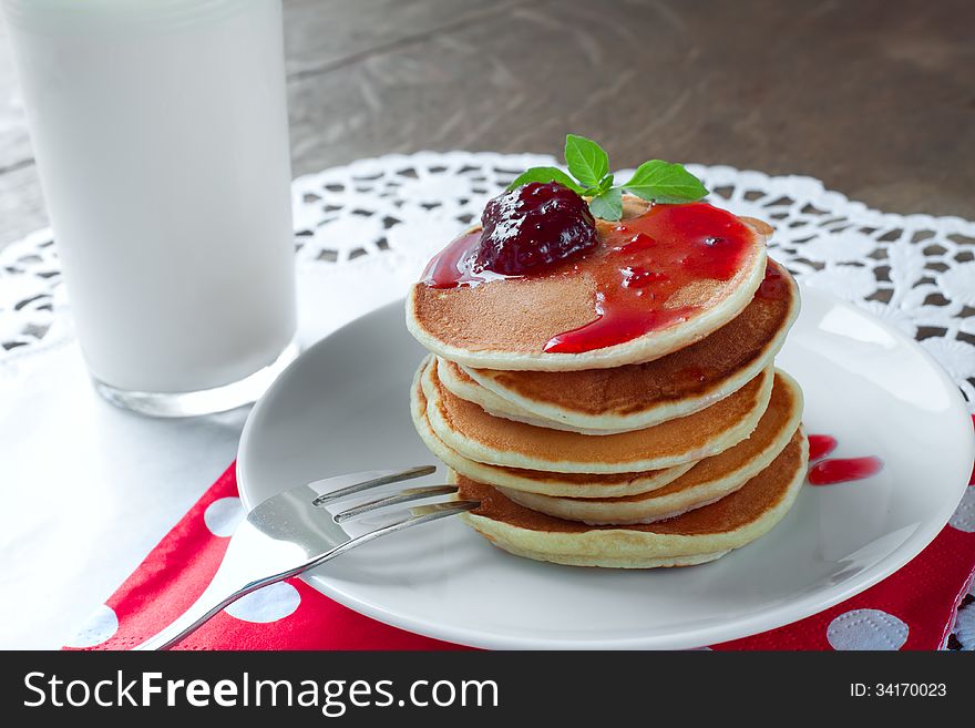 Pancakes on a white plate with strawberry jam. Pancakes on a white plate with strawberry jam