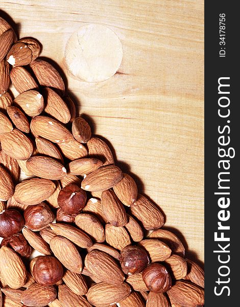 Closeup of almonds and filbert nuts on wooden background