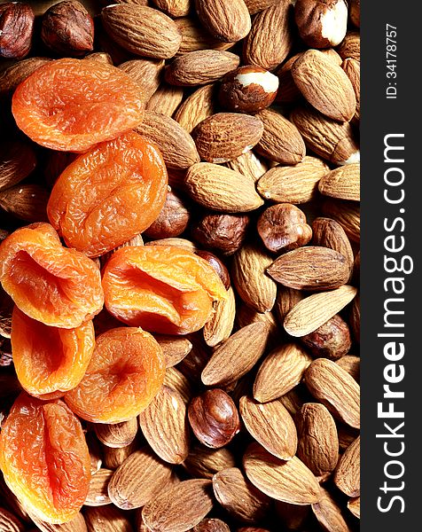 Closeup of dried apricots lying on almonds and filbert nuts. Nice background. Closeup of dried apricots lying on almonds and filbert nuts. Nice background