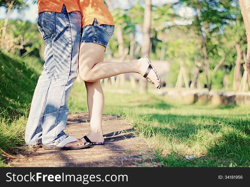 The romantic couple's legs and outdoor background