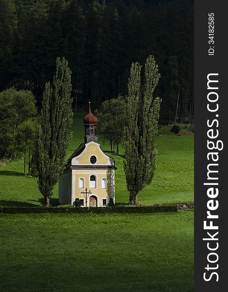 Small church surrounded with green grass and trees Austria