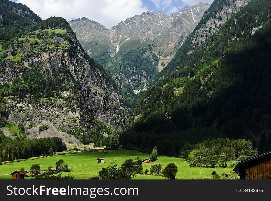 Small village surrounded with grass at the foot of Alps mountains,Austria.