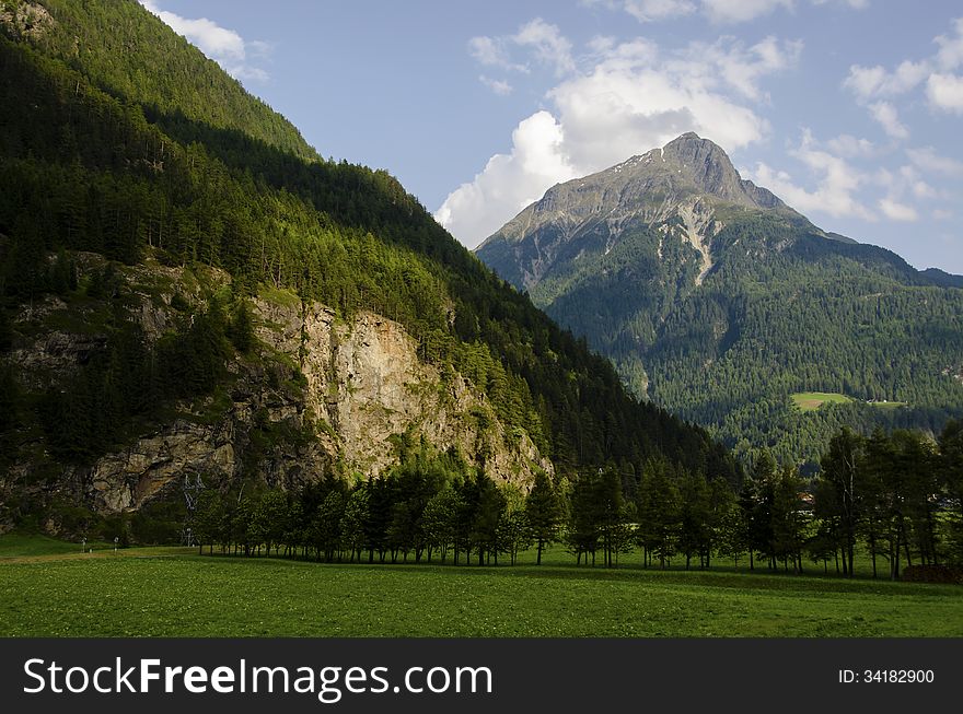 Austrian landscape of the alps mountains peak with green field , Austria.