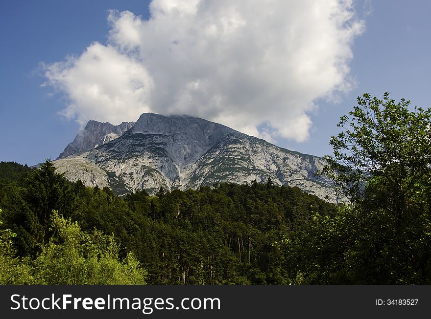 Austrian landscape of the alps mountains with green forest cloud and blue sky