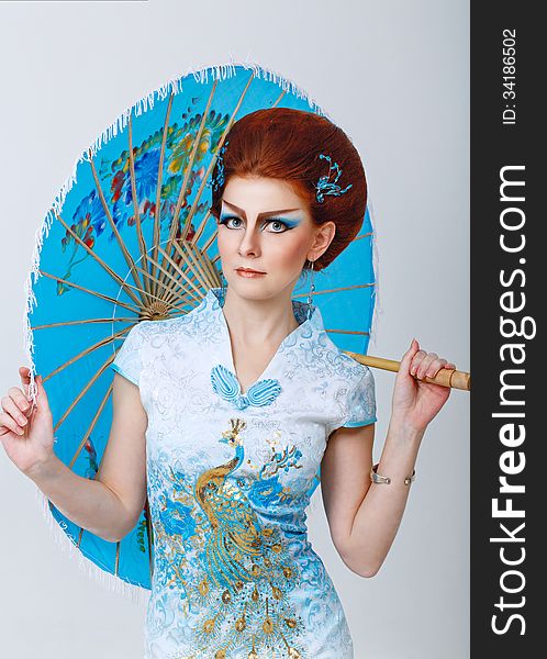 Geisha In A Smart Dress With Umbrella