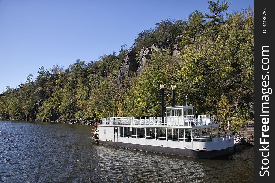 Paddle steamer or river boat stands anchored on shore. Autumn on the St. Croix River in Minnesota/Wisconsin. Paddle steamer or river boat stands anchored on shore. Autumn on the St. Croix River in Minnesota/Wisconsin