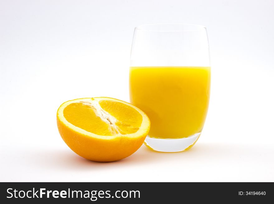 Glass of orange juice and orange slice on white
