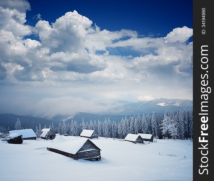 Winter mountain landscape with wooden huts and fresh snow. Carpathian mountains, Ukraine. Winter mountain landscape with wooden huts and fresh snow. Carpathian mountains, Ukraine