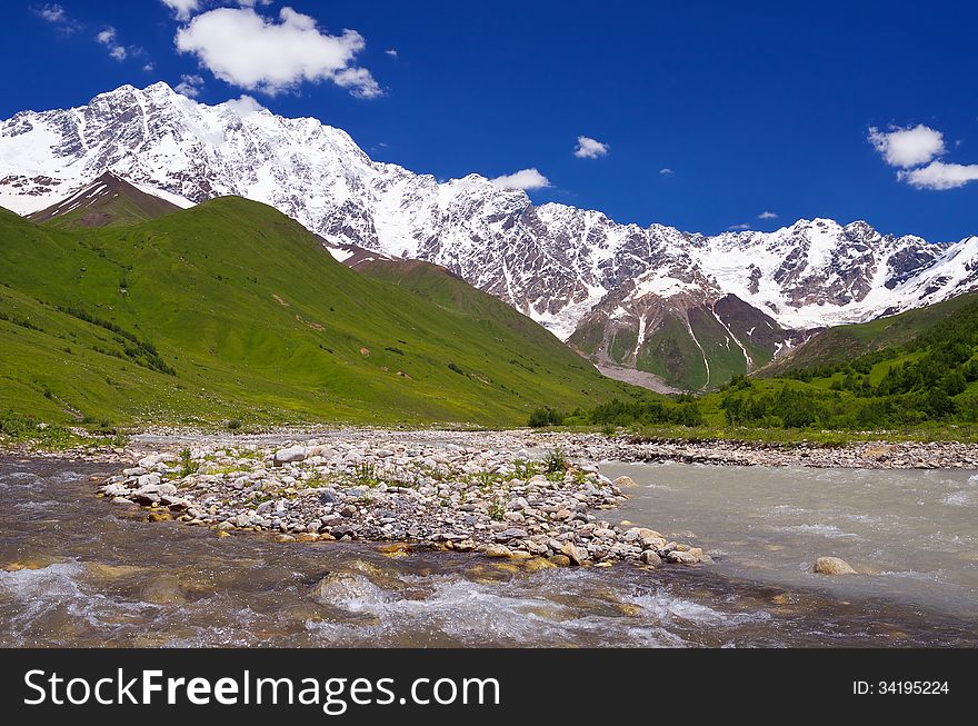 Mountain river in a valley. Shkhara Ridge Mountains, Georgia, Caucasus. Mountain river in a valley. Shkhara Ridge Mountains, Georgia, Caucasus