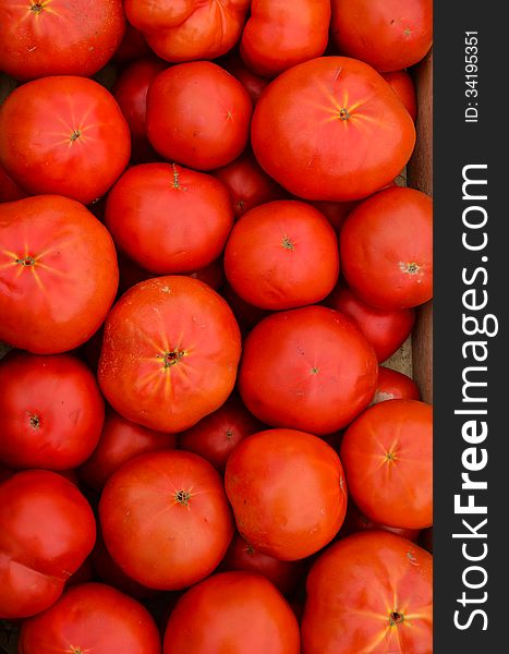 Full frame of tomato background - heap of tomato in wooden crate ready for sale