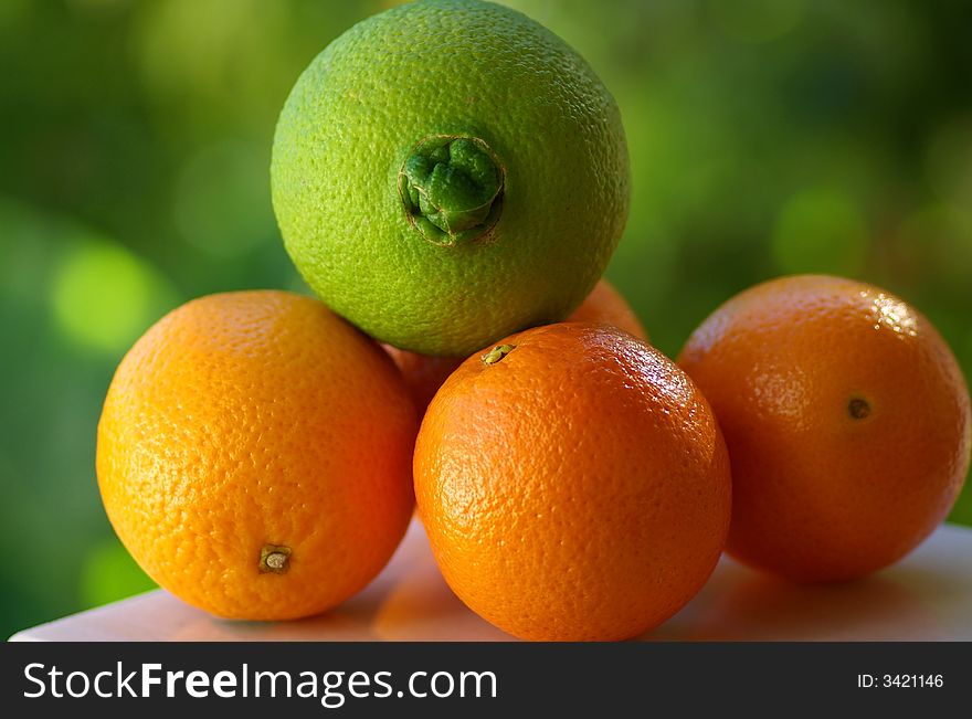 A green orange and other mature oranges.