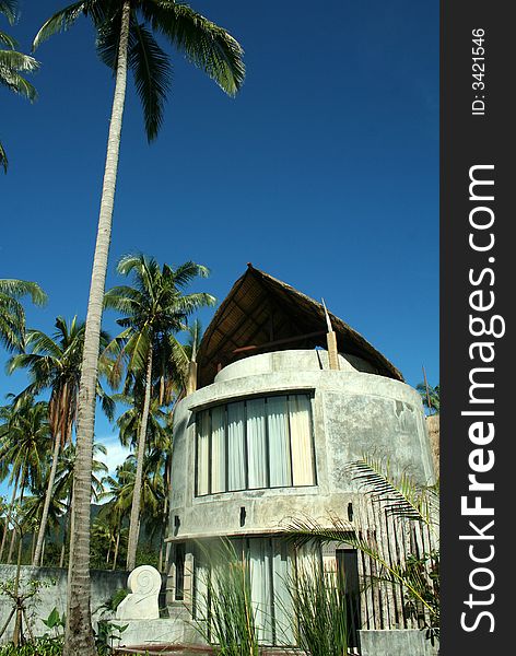Modern house near tropical beach with palm trees and blues sky background. Modern house near tropical beach with palm trees and blues sky background.