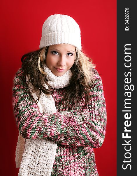 Winter portrait of a beautiful young woman is freezing with a cap and a scarf. Winter portrait of a beautiful young woman is freezing with a cap and a scarf