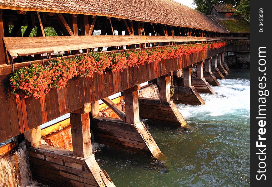 A swiss traditional design wooden bridge over Aare river in the city of Thun in sunset light. A swiss traditional design wooden bridge over Aare river in the city of Thun in sunset light.