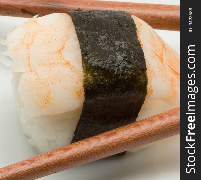 Japanese sushi with chopsticks on a white plate