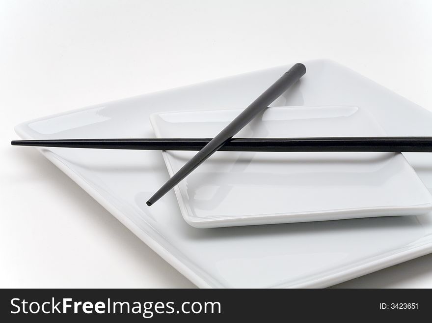 Crossed chopsticks on white plates