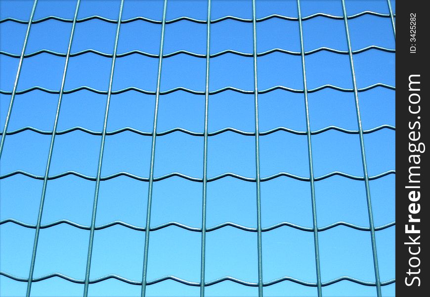 Fence over a blue background with green meshes