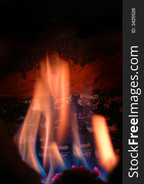 Closeup of flames in a fireplace with burning wooden log