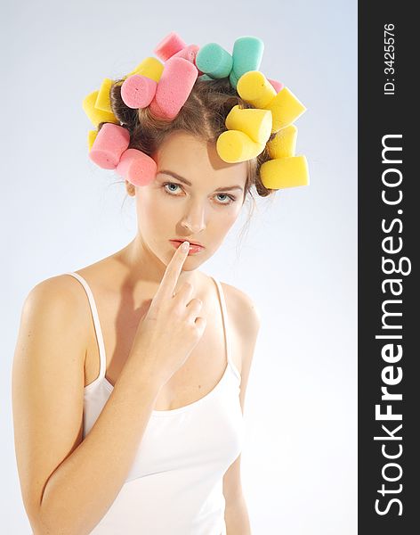 An young woman with curlers on her head. An young woman with curlers on her head