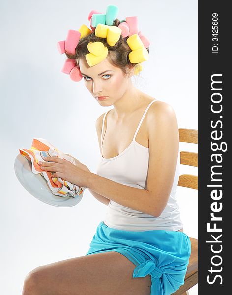 An young woman with curlers and plate. An young woman with curlers and plate