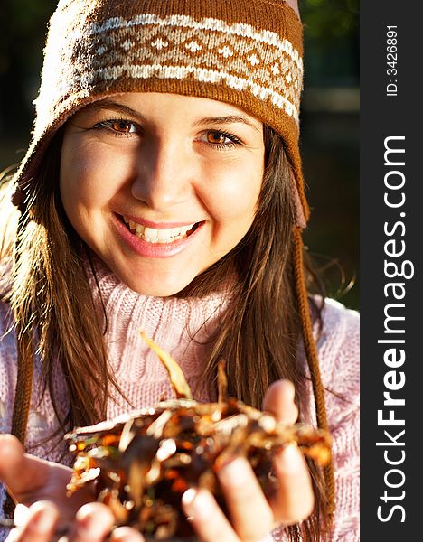 Beautiful young girl with golden leaves in her hands - great smile. Beautiful young girl with golden leaves in her hands - great smile