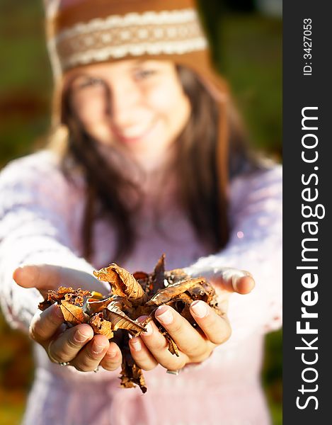 Beautiful Autumn - beautiful young girl holding golden leaves in her hands - focus on them