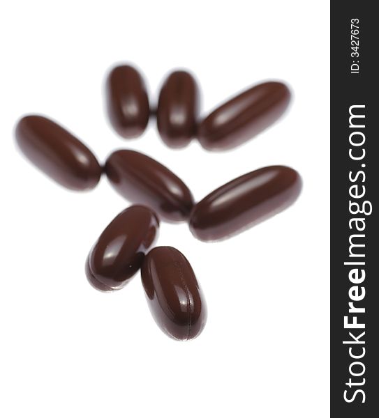 Brown Pills On White Background, Close-Up Shot, Focus On Front