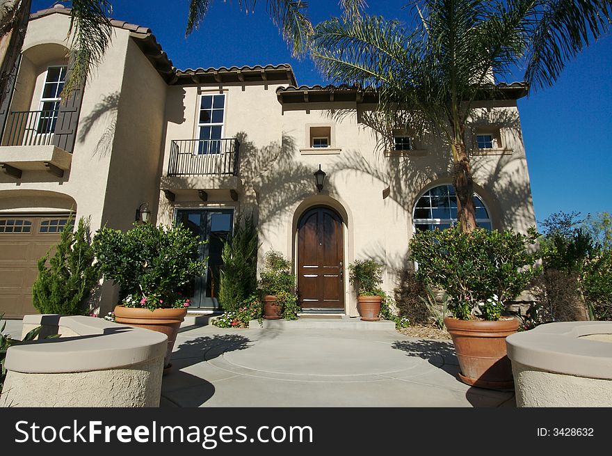 A newly constructed, modern american home with fresh landscaping & palm trees. A newly constructed, modern american home with fresh landscaping & palm trees.