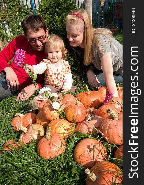 Little girl and her parents in a field of pumpkins. Little girl and her parents in a field of pumpkins